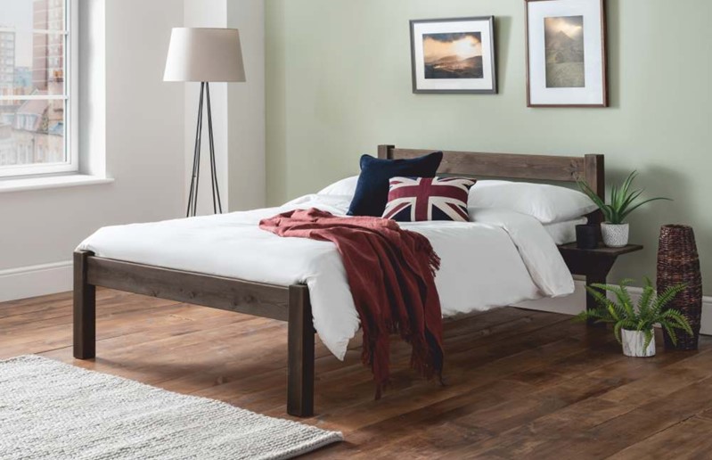 A dark wood bed frame in a bedroom setting